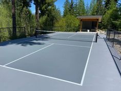 a tennis court surrounded by lots of trees