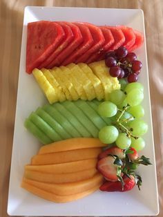 a white plate topped with sliced fruit and veggies