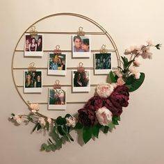 a circular metal frame with flowers and photos on it, hanging from the wall above