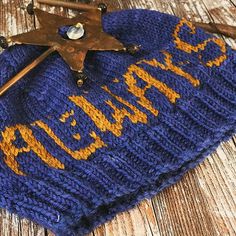 a blue knitted hat with a star on it and an old wooden cross hanging from the top