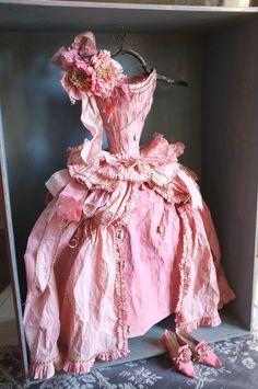 a pink dress and shoes are sitting on the floor