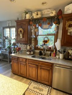 a kitchen with wooden cabinets and stainless steel dishwasher in the center, surrounded by potted plants