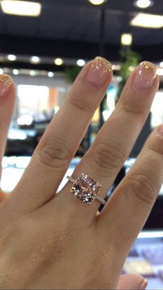 a woman's hand with a ring on it and a diamond in the middle