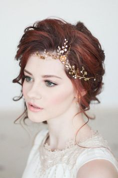 a woman with red hair wearing a gold head piece and pearls in her hair is looking off to the side