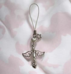 an angel ornament is hanging on a pink and white fabric with silver beads