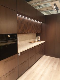 an empty kitchen with wooden cabinets and white counter tops, along with wood flooring