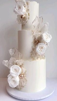 a three tiered white wedding cake decorated with flowers