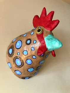 a ceramic rooster head with blue dots on it