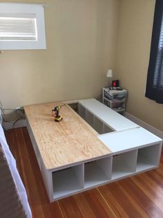 a bed room with a wooden floor and white shelves next to a wall mounted air conditioner