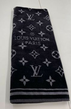 the louis vuitton towel is laying on top of a white counter next to a wall