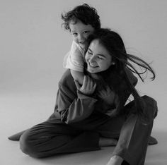 a woman sitting on the floor holding a child