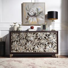 a living room with a rug, table lamp and painting on the wall behind it