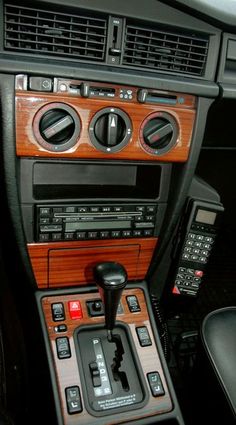 the interior of a modern car with wood paneling and buttons on the console area