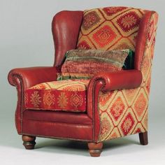 a red leather chair with colorful pillows on it