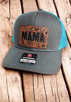 a gray and blue trucker hat sitting on top of a wooden table next to a bottle