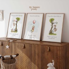 three framed pictures on top of a wooden cabinet next to a basket and stuffed animal