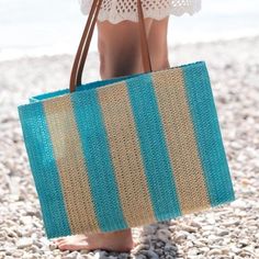 Brighten up your beach look with Shiraleah's Filomena Stripe Straw Tote. Made from lightweight paper straw, it features sleek circular handles and a colorful stripe pattern. Perfect for carrying all your essentials, make a fashion statement in the sun with this playful and roomy tote. Made in China Paper straw and PU Double shoulder straps Magnetic snap closure 1 inner slip pocket Dimensions: 17.5 x 7 x 12 in (44.5 x 17.8 x 30.5 cm) Color: Turquoise & Natural Stripe Striped Woven Straw Bag, Lightweight Straw Beach Bag, Casual Striped Woven Straw Bag, Casual Striped Straw Bag, Striped Beach Bag With Braided Handles, Striped Beach Bag For Everyday Summer Use, Striped Woven Rectangular Beach Bag, Spring Striped Beach Bags, Spring Beach Striped Bags