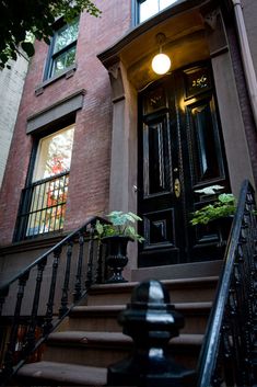 an entrance to a brownstone townhouse with wrought iron railing