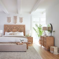 a bedroom with white walls and wooden furniture