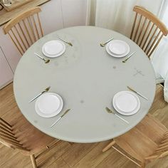 the table is set with white plates and silverware