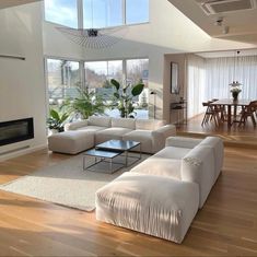 a living room with white furniture and large windows