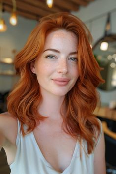 Woman with long red hair and light freckles smiling in a softly lit indoor setting. Red Gold Hair Color, Brown Hair Red Undertones, Dark Copper Red, Copper And Blonde, Rarest Hair Color, Vibrant Red Hair, Red Balayage Hair, Red Hair Trends, Red Hair Color Ideas