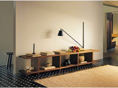 a room with black and white tile flooring and a wooden shelf filled with books