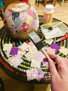 a person is making patchwork pieces on a table with a paintbrush and brush