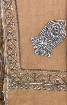 an image of a piece of cloth with embroidered designs on the front and back side