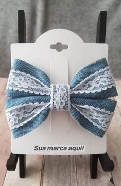 a bow tie that is on top of a wooden stand in front of a gray background