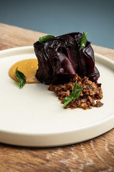 a white plate topped with food on top of a wooden table