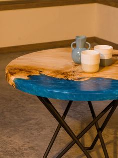 a wooden table with two cups on it