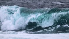 a person riding a surfboard on top of a large wave in the ocean,