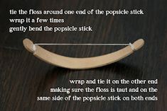 a close up of a wooden object on a table with text describing how to wrap the floss around one end of the popsicle stick