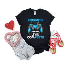 a t - shirt that says, kindergarten level complete with video game controllers