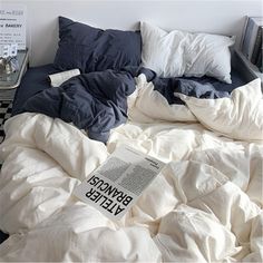 an unmade bed with blue and white sheets