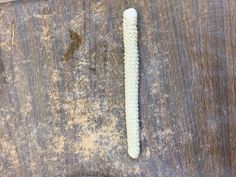 a toothbrush sitting on top of a wooden table next to a piece of wood