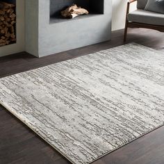 a white rug with lines on it in front of a fireplace