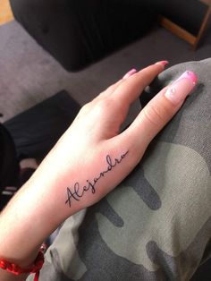 a woman's hand with the word alexandria tattooed on it