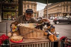 a man is selling stuffed animals on the street