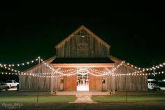 a barn with lights strung around it at night