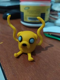 a yellow toy sitting on top of a wooden table