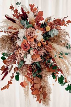 a bridal bouquet with feathers and flowers