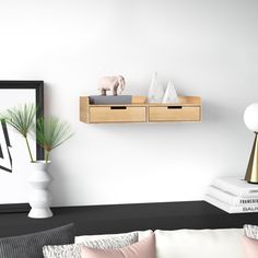 a living room filled with furniture next to a wall mounted shelf and two white vases