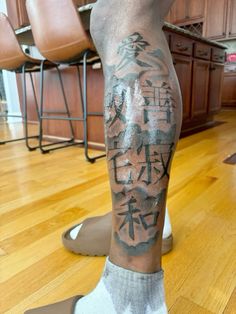 a man's leg with chinese writing on it in the middle of a kitchen