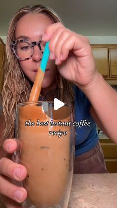 a woman is drinking from a glass with a straw in her mouth and the caption reads, the best instant coffee recipe