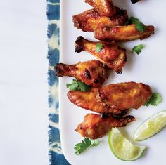 chicken wings with cilantro and lime on a white plate