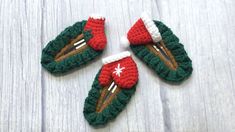 three crocheted christmas ornaments on top of a white wooden table next to each other