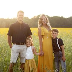 a man and two children standing in tall grass