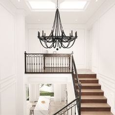 a chandelier hanging from the ceiling in a room with white walls and stairs